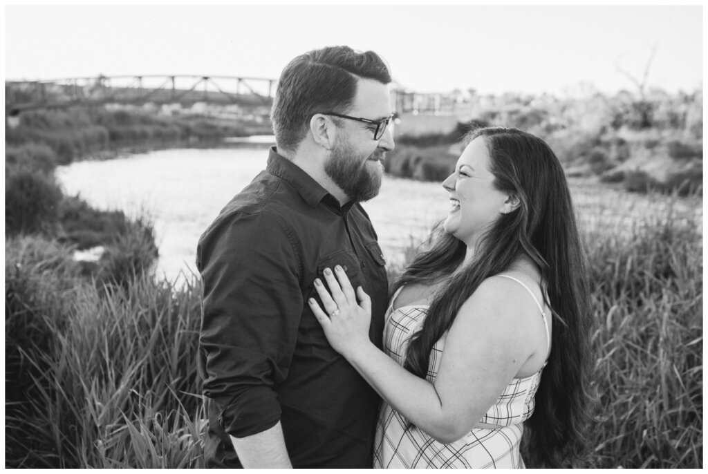 Dustin & Kristyn - Wascana Trails Engagement - 07 - Engaged couple laugh near river