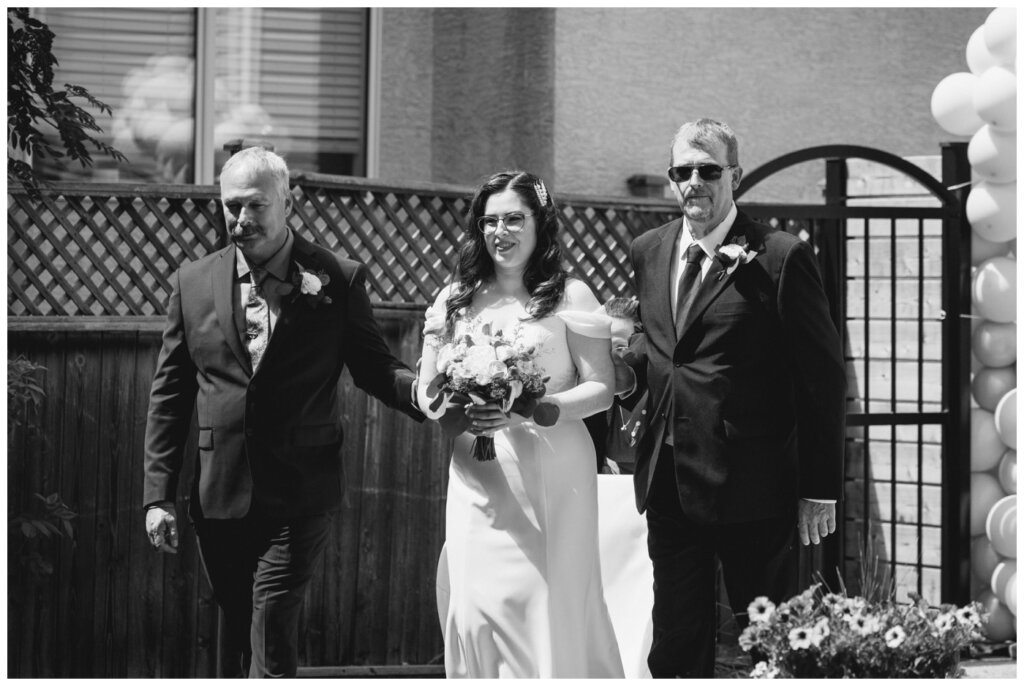 Charlie & Brittany - Regina Wedding - 09- Bride escorted into the ceremony