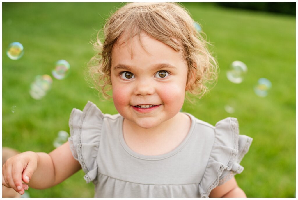 Piluk Family - TC Douglas Building - 12 - Little girl in grey dress plays in bubbles