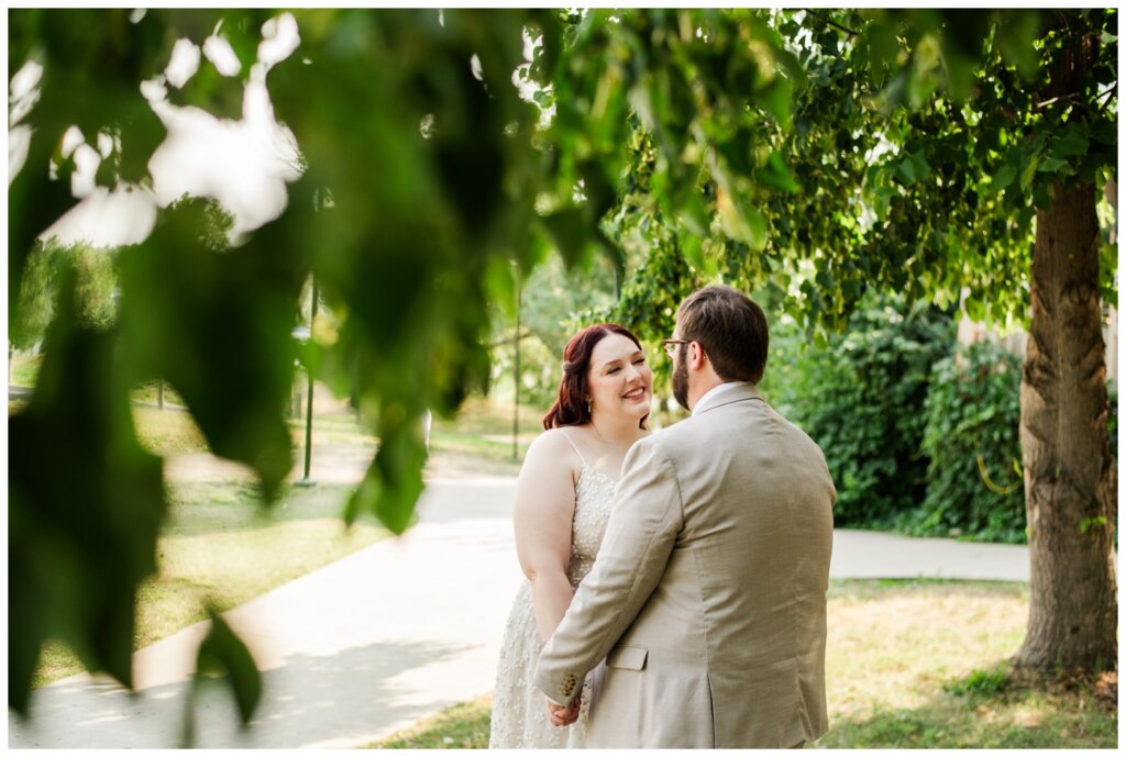 Darren & Amber - Regina Wedding - Summer Wedding 2024 - 23b - Wascana Park - Bride and groom hold hands