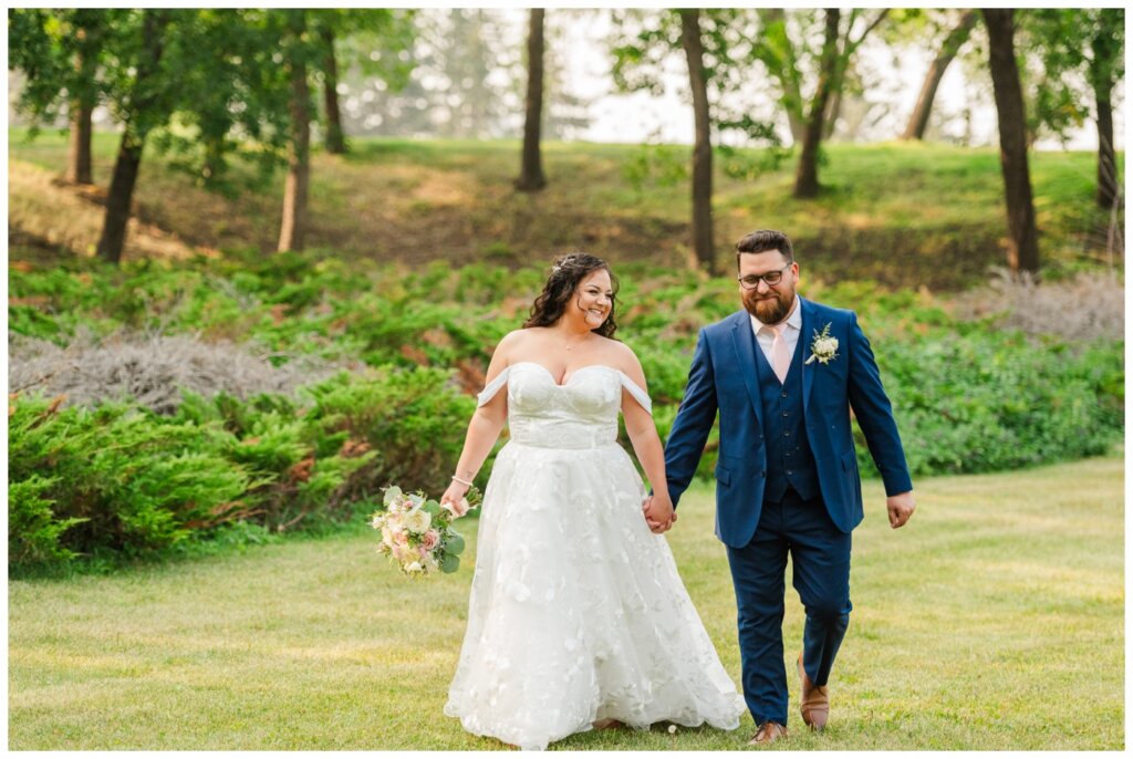 Dustin & Kristyn - Regina Wedding - 24 - University of Regina - Bride & groom stroll through grass