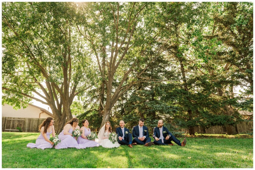 Evan & Melissa - Regina Wedding - Howell Park - 20 - Bridal party sits in lavender dresses and blue suits