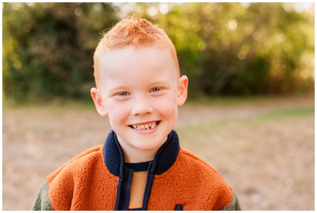 Pelletier Family 2024 - Saskatchewan Science Centre -03 - Boy with red hair smiles at the camera