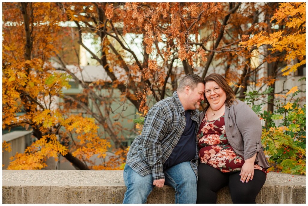 Scott & Ashley - Regina Family Photography - Provincial Archives - 03 - Couple snuggle on stone wall