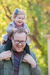 Piggy back rides during Regina Family photography session in Wascana Park