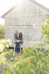 Couple kissing with sun flare on the farm