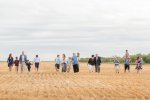 Extended family walking in harvested wheat field