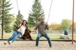 Husband and wife playing on the swings at the Lumsden campground