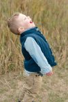 Three year old boy laughing at geese as they fly overhead