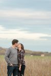 Couple kissing in tall grass in the valley