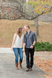 Engaged couple walking through the fall leaves
