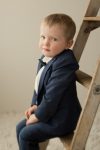 Little boy in suit sitting on a ladder