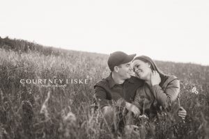 Man and woman sitting in a field of tall grass in Lumsden