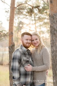 Man in plaid shirt and woman in tan sweater during their engagement session
