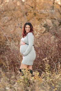 Mother to be laughs to herself during her maternity session with Courtney Liske Photography