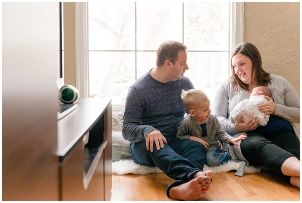 Regina Family Photography - Jensen Newborn - Keltie-Josh-Kayden - In home Family Session - Family seated on hardwood floor