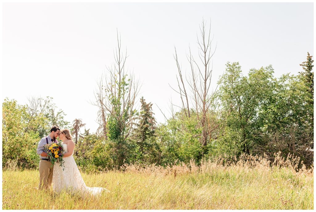 Regina Wedding Photographers - Ryan - Aeliesha - Bride & Groom in open field in Regina Park
