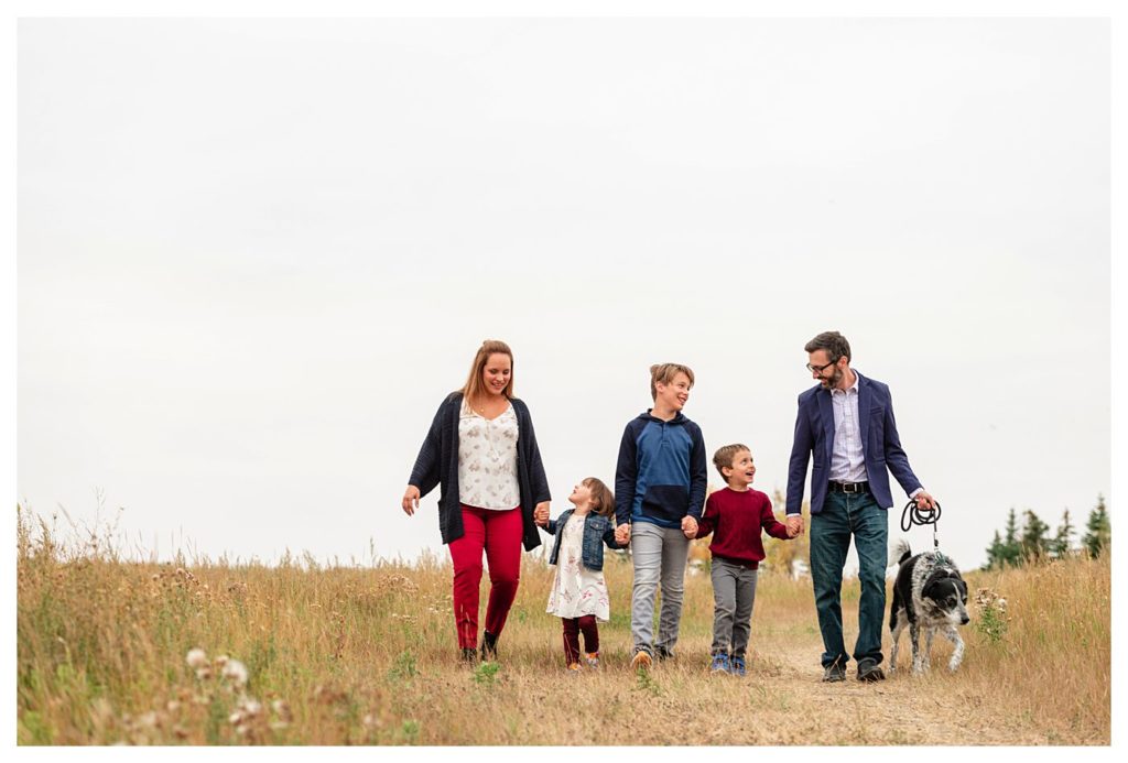 Schlamp Family 2020 - 001 - Regina Family Photographer - Family walking through the field
