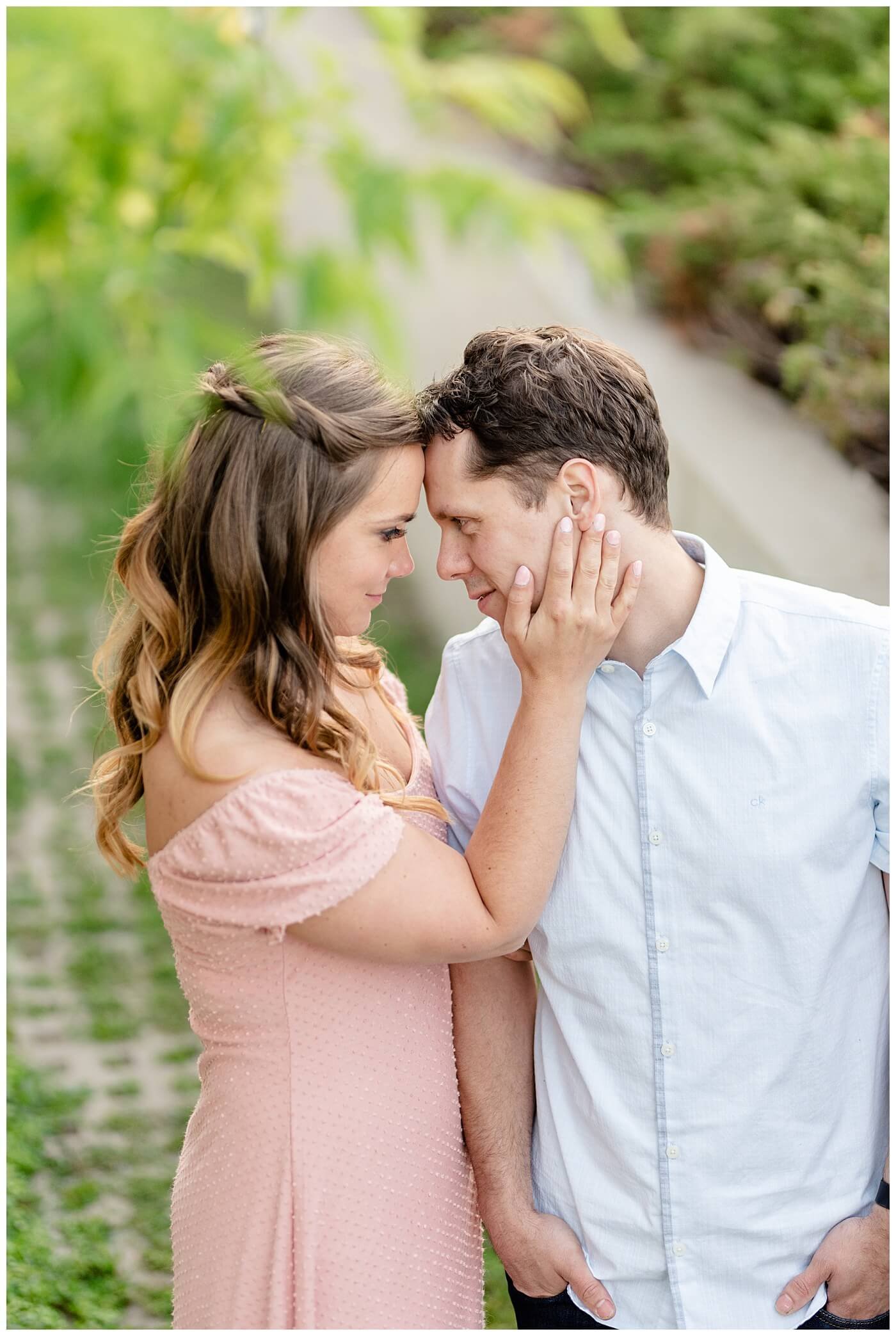 Regina Engagement Photographer - Adam - Sarah - Natural Light Engagement Session in Wascana Park - CBC Regina Building - Pulling in her future husband for a kiss