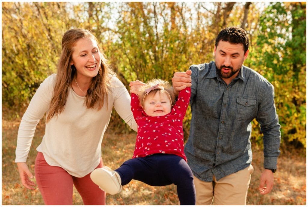 Regina-Family-Photography-Eyre-Family-Douglas-Park-Hill-06-Parents-swinging-child-