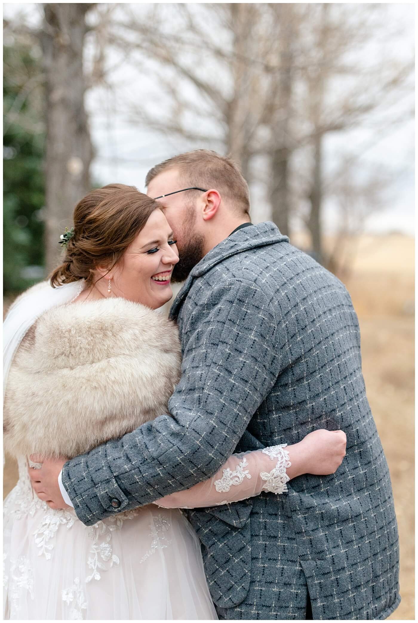 Regina Wedding Photographer - Kolton - Maxine - Groom whispers in the brides ear as he keeps her warm