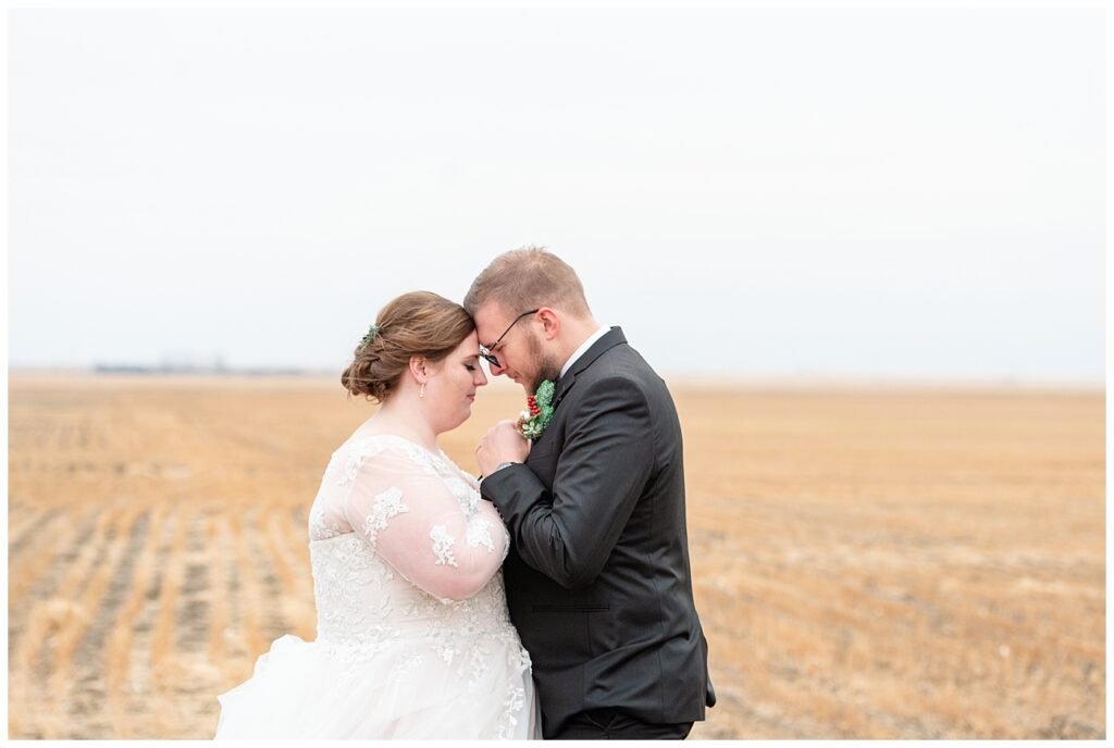 Regina Wedding Photographers - Kolton - Maxine - Bride & groom stand in a harvested wheat field