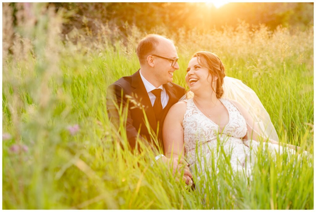 Colter & Jillyan - Encore Wedding Session - 10 - Bride and groom sitting in field with sunflare