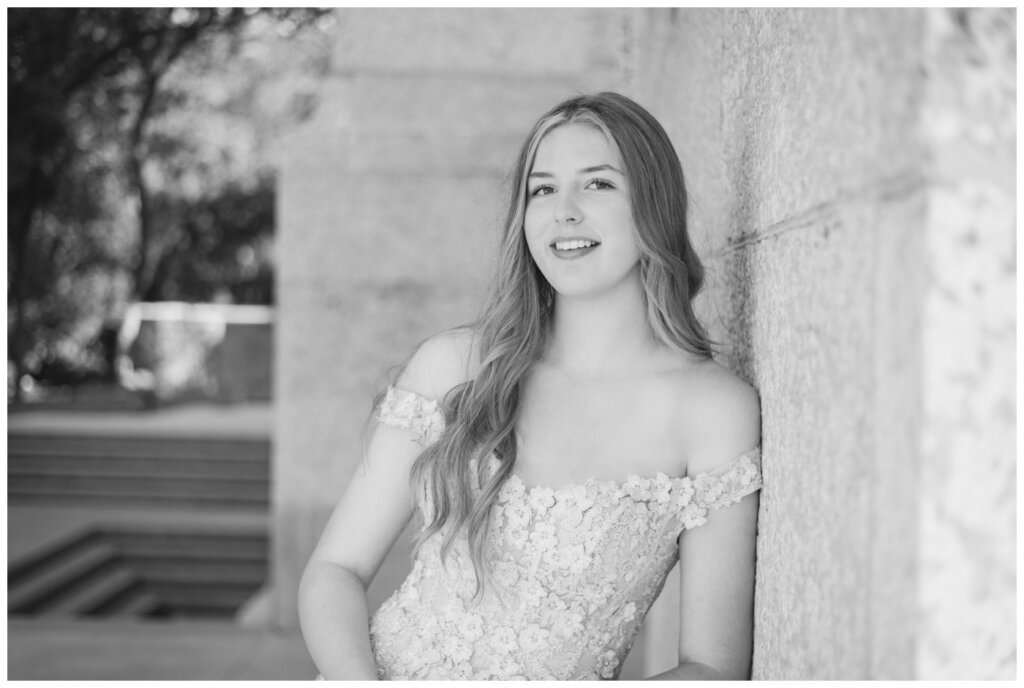 Graduate leans against the stone of the Saskatchewan Legislative Building