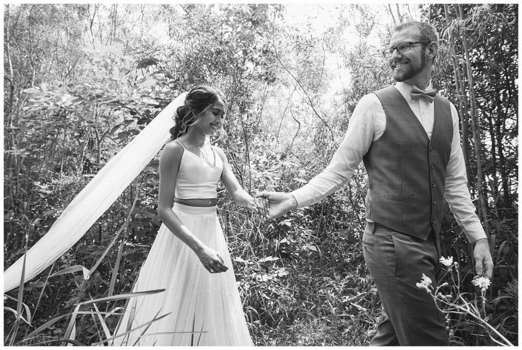 Stephen & Sarah Wedding - 11 - Groom leading bride through forest area at Wascana Park