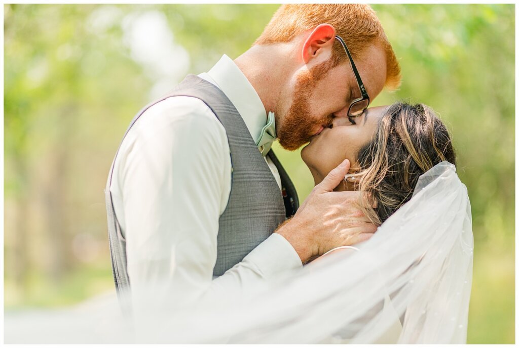 Stephen & Sarah Wedding - 16 - Bride & Groom kissing with veil swooping