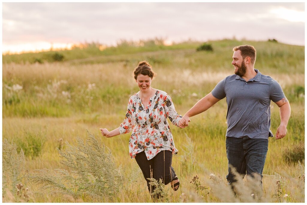 Mitch & Val - Engagement Session in Wascana Habitat Conservation Area - 11 - Couple frolicking in a field