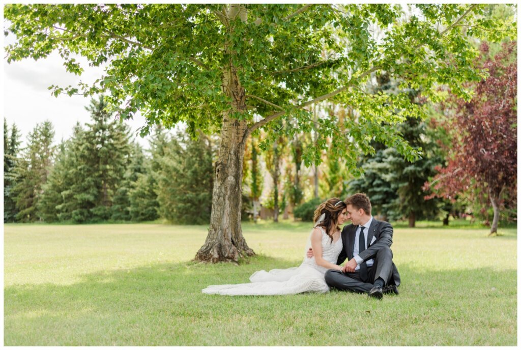 Taylor & Jolene - Emerald Park Wedding - 13 - Bride & Groom sit quietly in the park