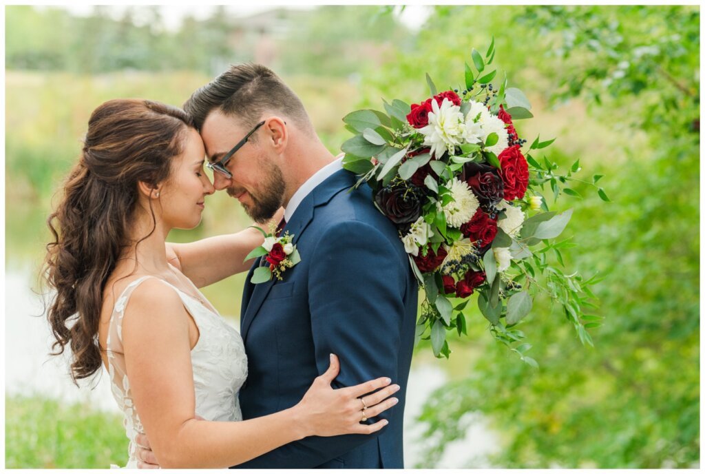 Andrew & Lacey - 28 - Bride & Groom nose to nose by lake at Kiwanis Park