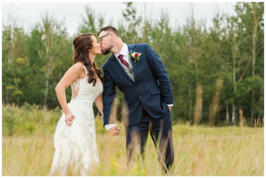 Andrew & Lacey - 38 - Bride & Groom kissing in the field