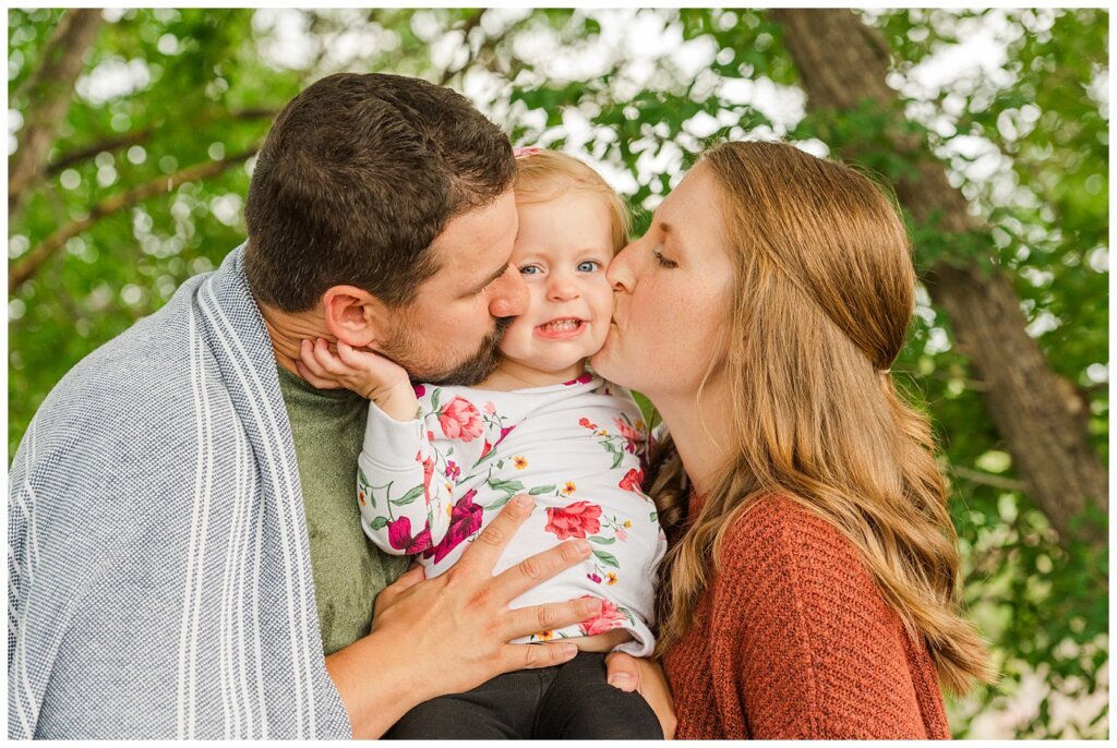 Eyre Family 2021 - AE Wilson Park - Family Photo Shoot - 09 - Mom and dad give daughter smooshy kisses