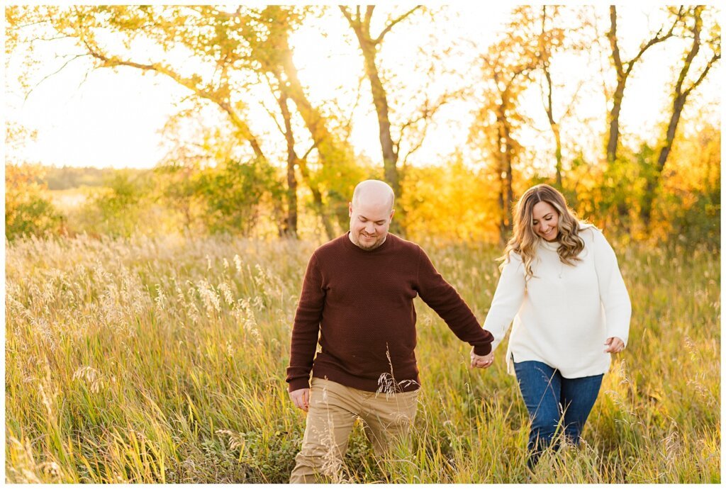 Trevor & Kim - Regina Engagement Session - Wascana Centre Habitat Conservation Area - 04 - Man leading woman through field