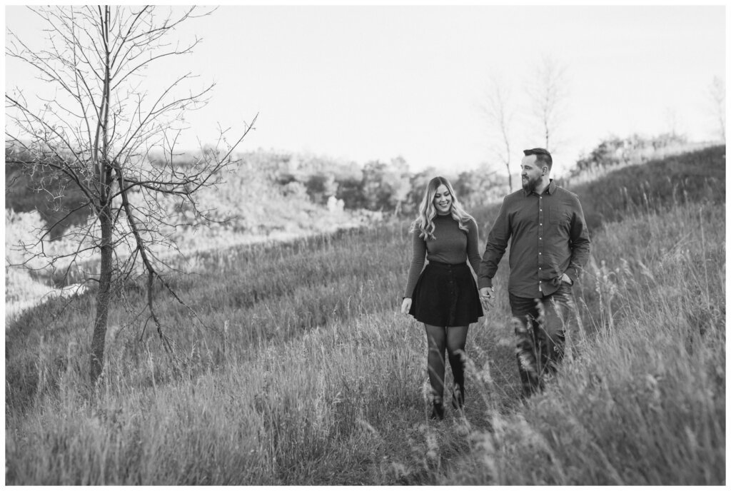 Jared & Jenna - Wascana Trails - 01 - Couple walking through field in black and white