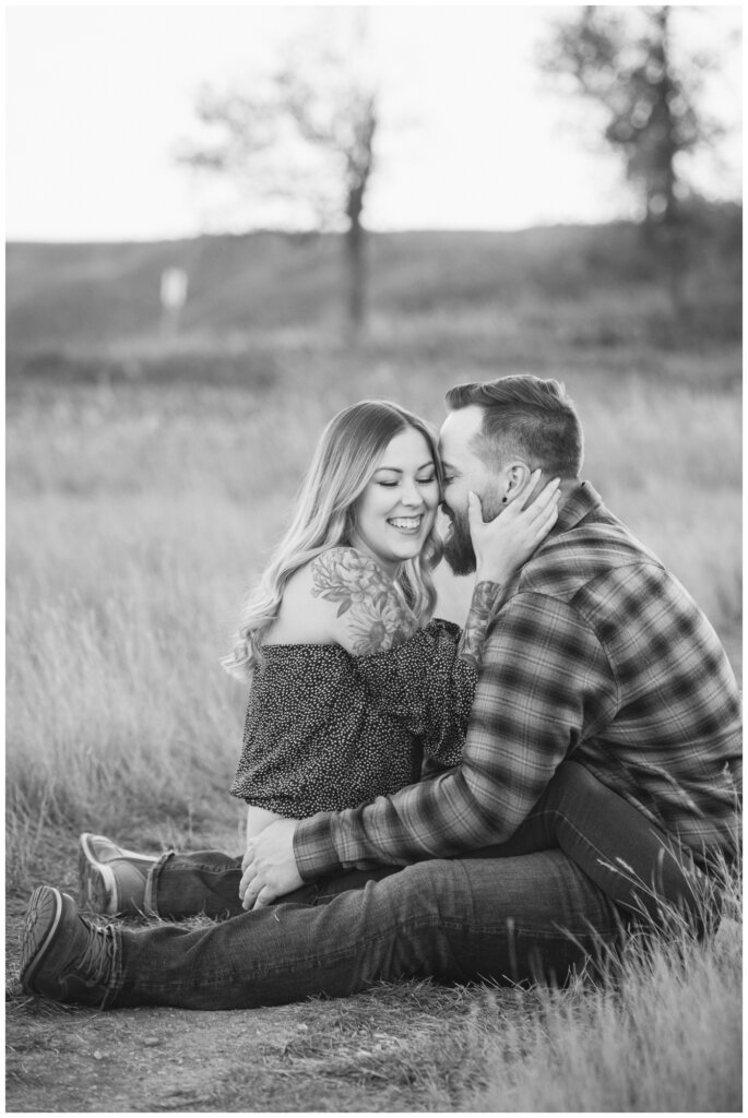 Jared & Jenna - Wascana Trails - 13 - Black and white photo of couple sitting on the ground facing each other