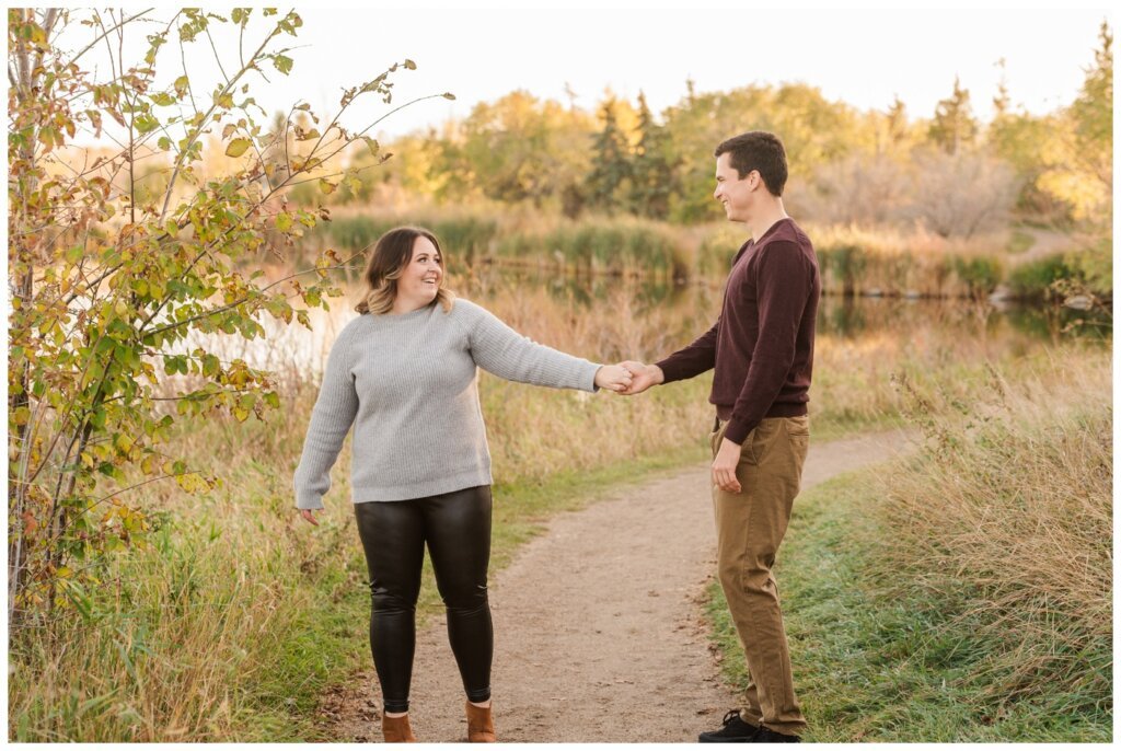 Regina Engagement Photography - Ben & Megan - Engagement Session at AE Wilson Park and Island - 09 - Woman twirling into man as they dance in the park