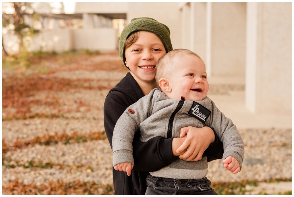 Regina Family Photographers - Keen Family - 2021 - TC Douglas Building - 03 - Big brother holding toddler little brother