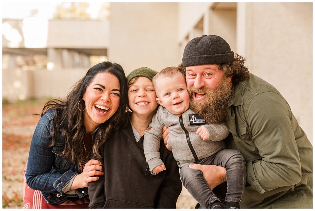 Regina Family Photographers - Keen Family - 2021 - TC Douglas Building - 06 - Family of 4 cheek to cheek smiling at camera