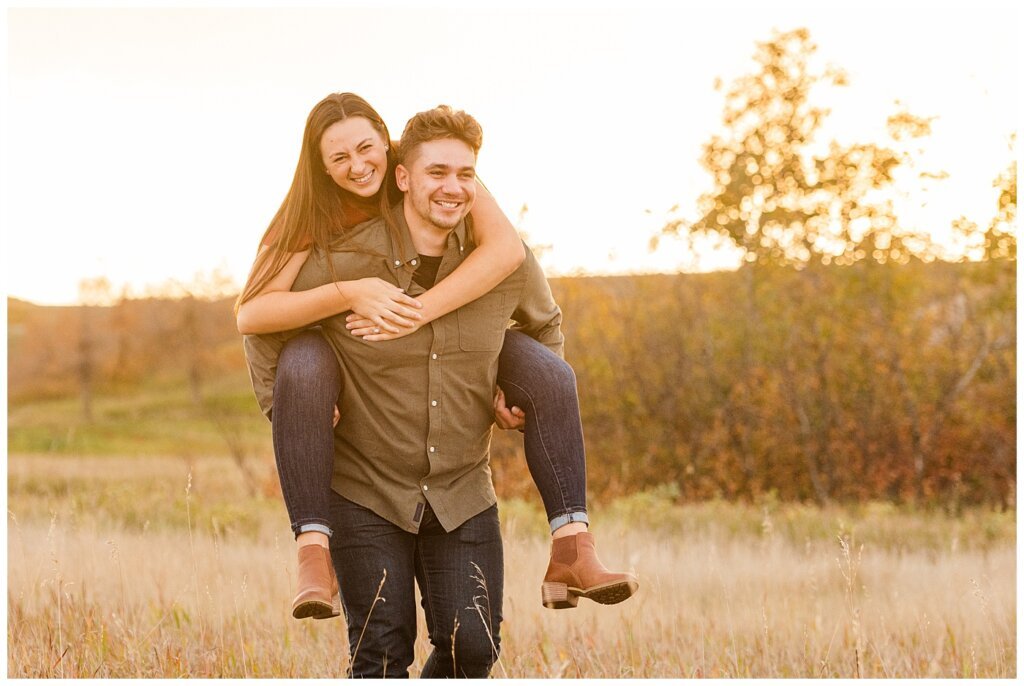 Tris & Jana - Engagement Session - Wascana Trails - 10 - Giving fiancee piggy back ride