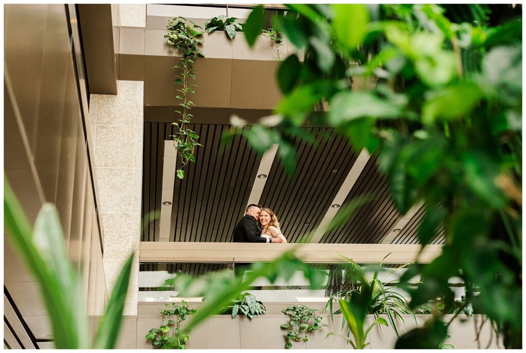 Matt & Ruth - 2022 Wedding - TC Douglas Building - Regina Wedding - Bride & Groom through plants