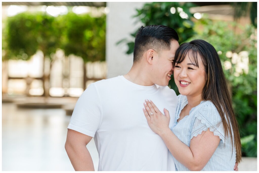 Benton whispering into Sam's ear at their engagement session in Regina