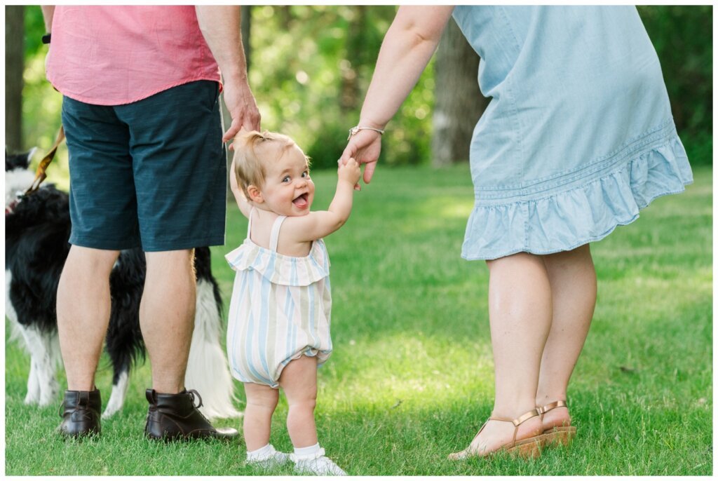 Filby Family 2022 - 06 - Saskatchewan Science Centre - Family holds hands while daughter smiles over her shoulder