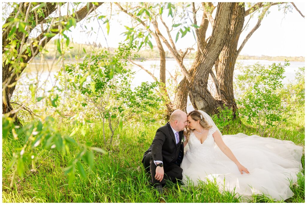 Trevor & Kim Wedding - 30 - Couple sitting by the edge of Wascana lake