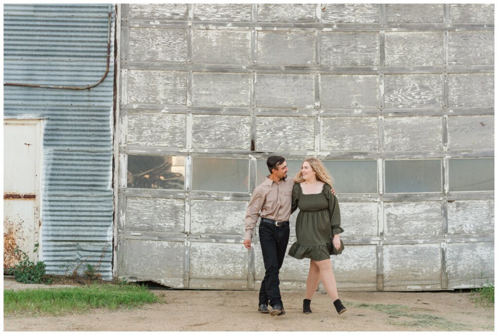 Orrin & Jade - 01 - Weyburn Engagement - Couple walks in front of faded door