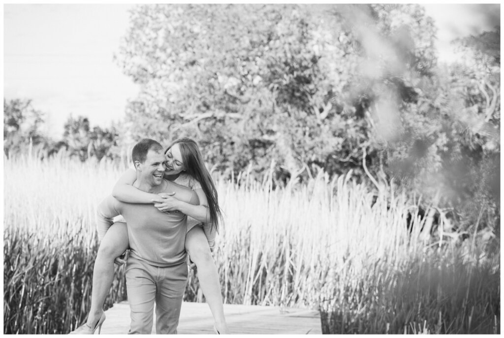 Ryan & Melissa - 09 - Wascana Habitat Conservation Area - Groom gives bride piggyback on dock