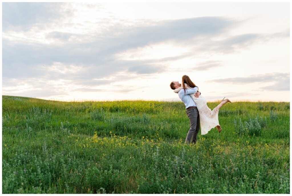 Ryan & Melissa - 17 - Wascana Habitat Conservation Area - Groom lifts and spins bride in a field of wild flowers