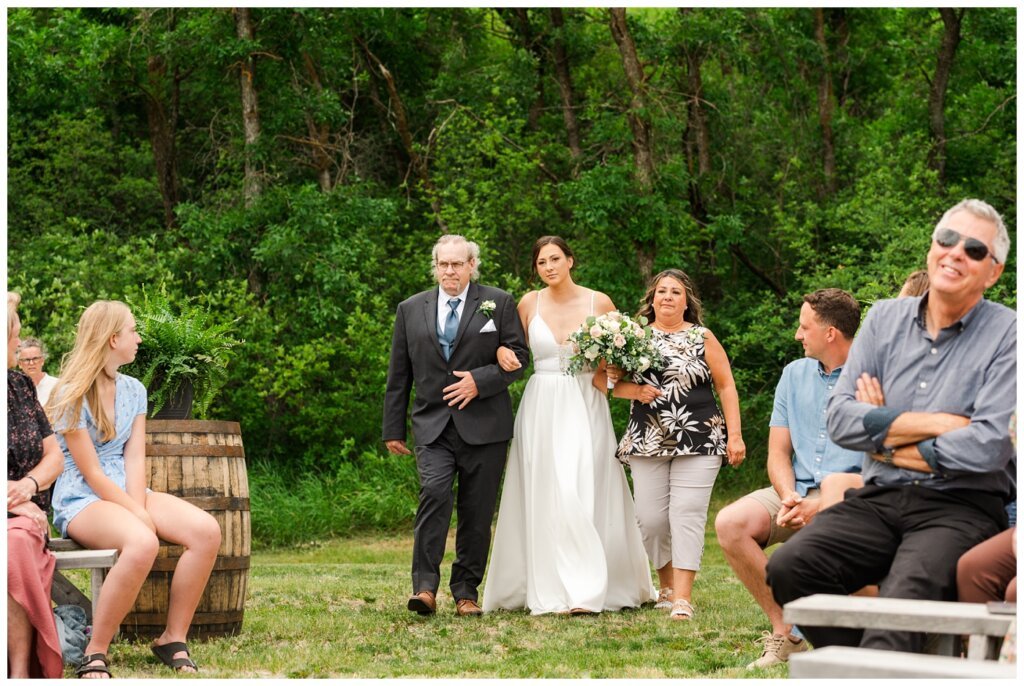 Tris & Jana - Lumsden Wedding - 15 - Bride is escorted down the aisle by her mom and dad